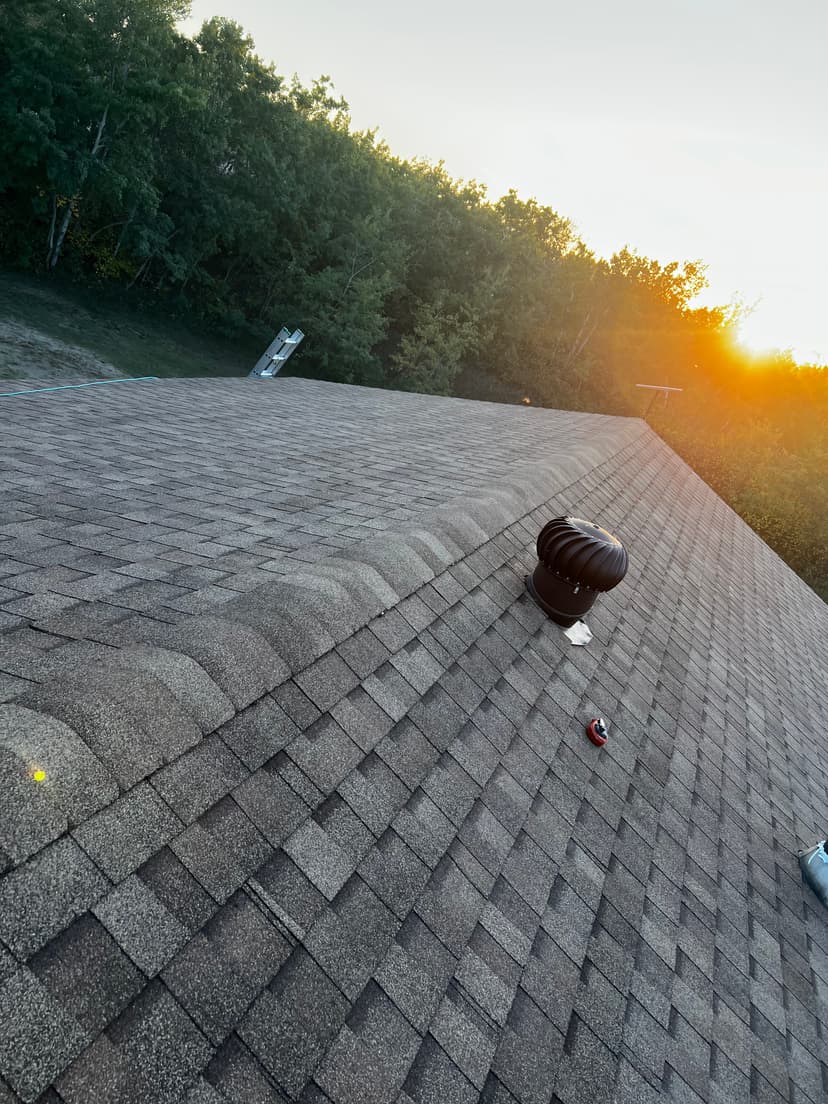 Completed asphalt shingle roof by WLG Homes in Saskatoon at sunset